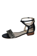 Black sandal with a patterned strap on a white background