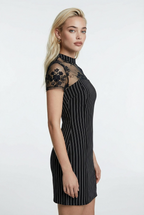 Woman wearing a navy dress with lace sleeves on a white background