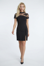 Woman wearing a navy and white striped dress with sheer sleeves on a white background