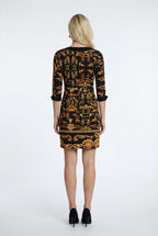 Woman wearing a black and orange patterned dress on a white background